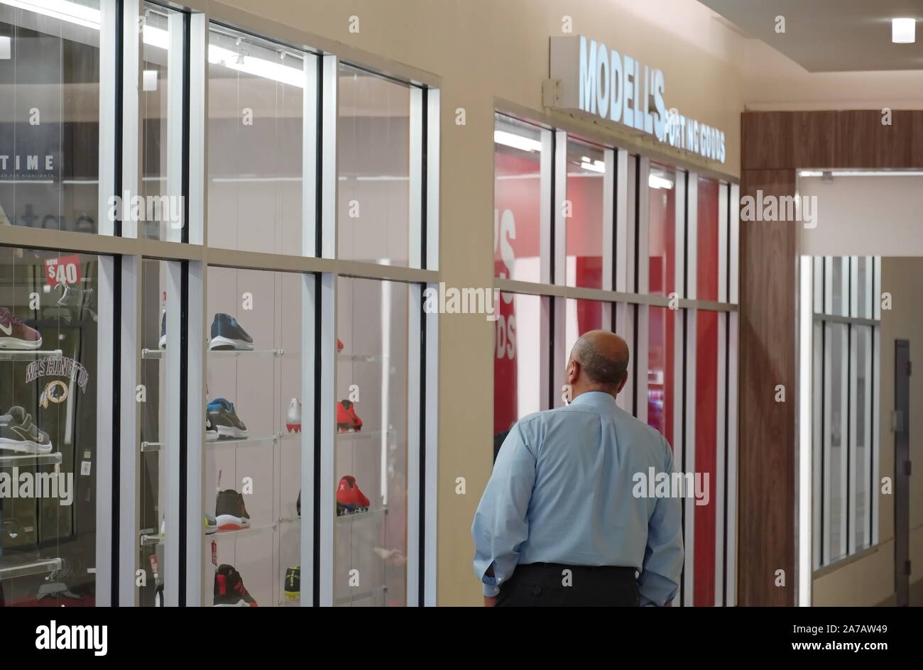 Alexandria, VA/USA - 24. September 2019: im mittleren Alter kaukasischer Mann starrt auf den Schuh Anzeige durch ein Fenster in der Mall Stockfoto