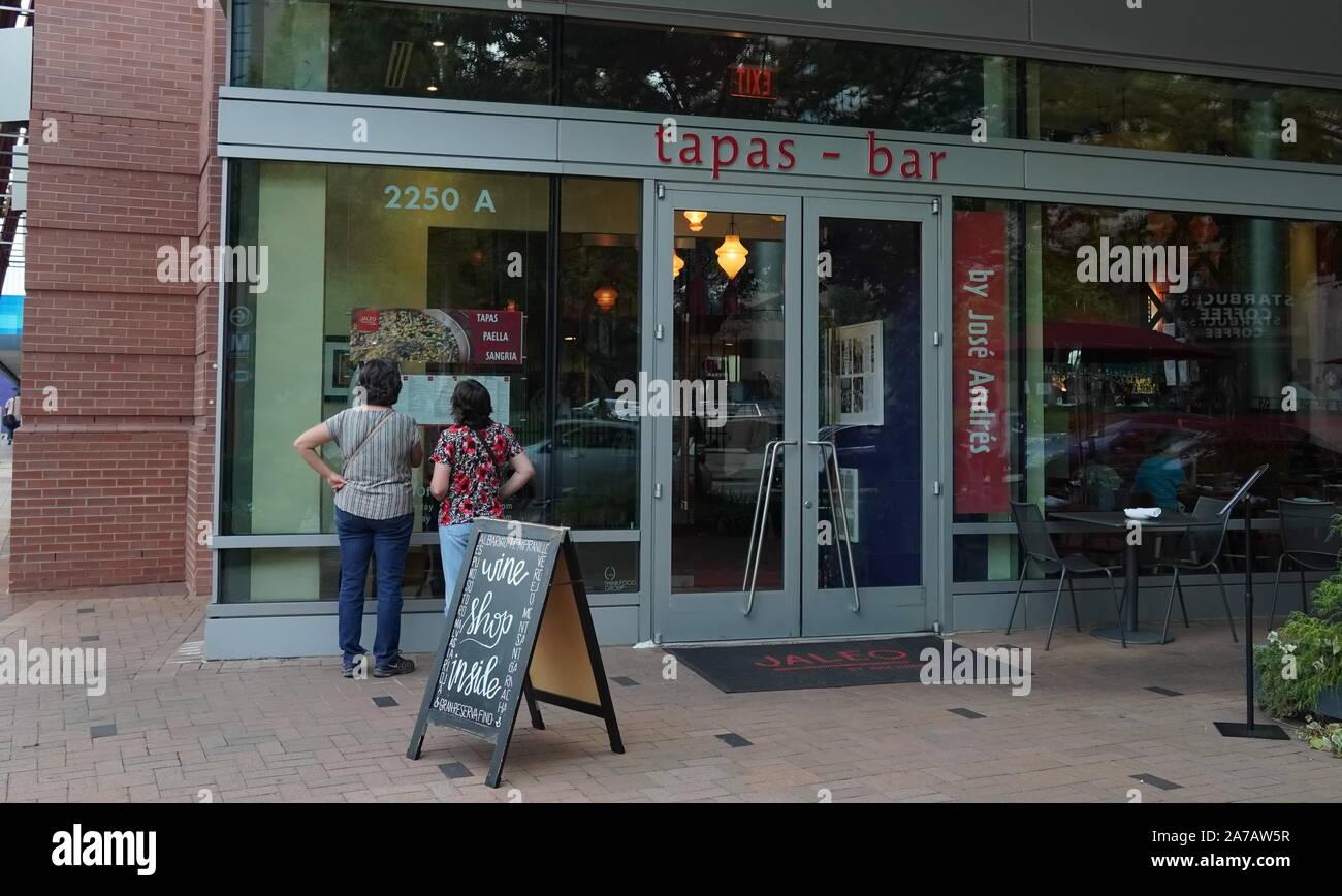 Arlington, VA/USA - September 23, 2019: Zwei Frauen an der Speisekarte vor einem Tapas Restaurant, auf der Suche nach der nächsten Mahlzeit Stockfoto