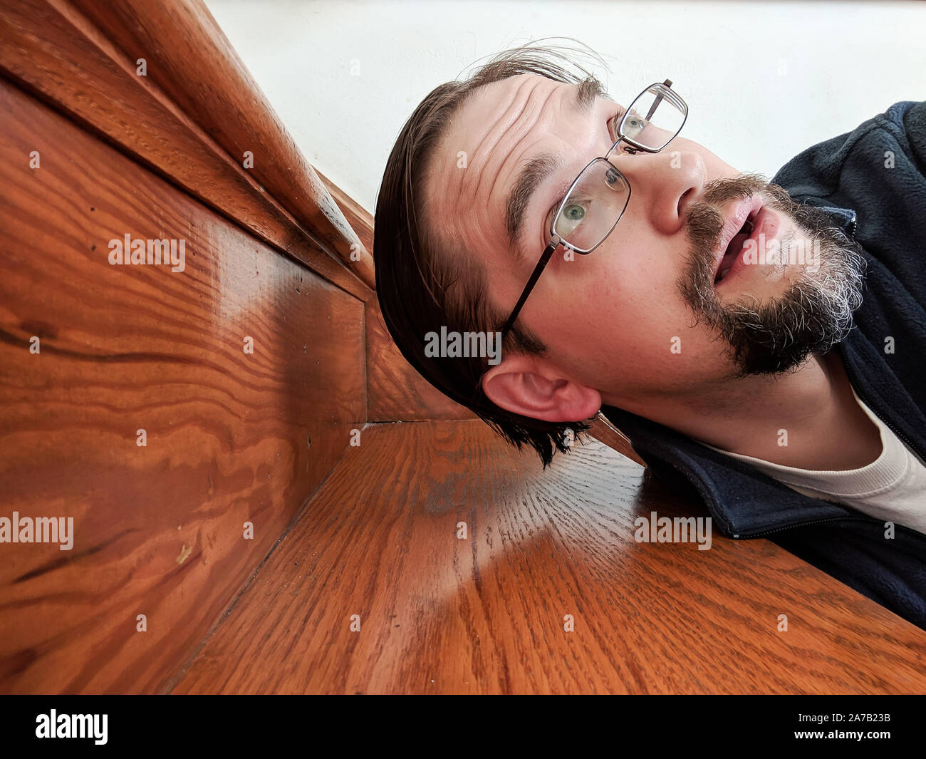 Mann gefallen auf Treppen Suchen nach oben aus dem Rahmen Stockfoto