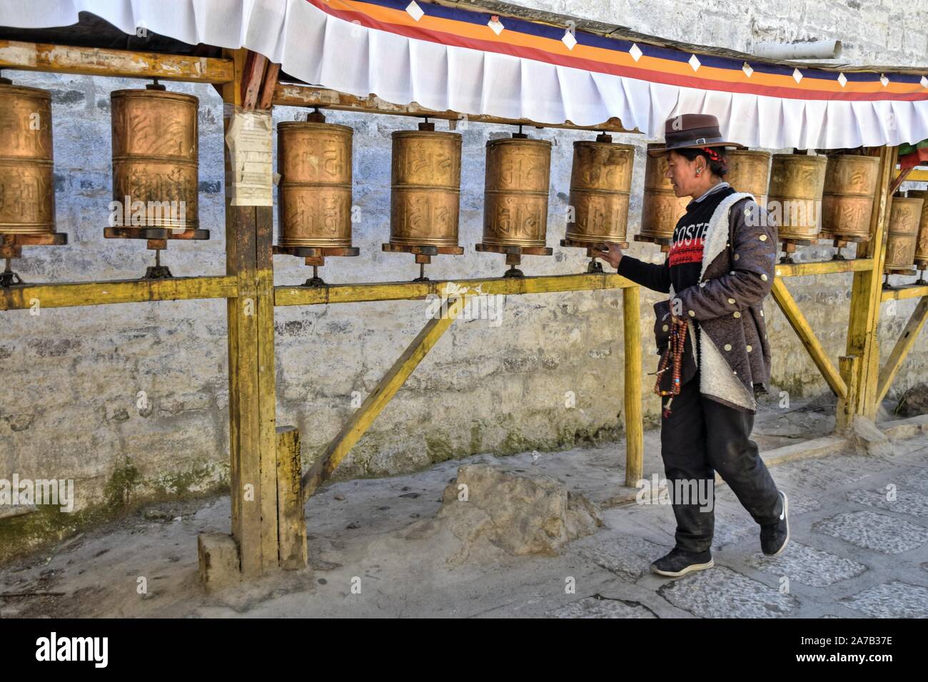 PALCHO KLOSTER GYANTSE COUNTY, Tibet - ca. Oktober 2019: Ein Mann Spaziergänge entlang der Promenade gesäumt Gebetsmühlen in Palcho Kloster. Stockfoto