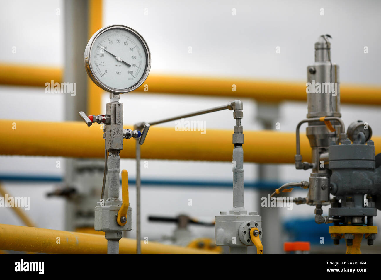 Industrielle Ausrüstung (Rohre, Manometer-/Druckmesser, Hebel, Armaturen, Indikatoren) in einer natürlichen Gasverdichterstation. Stockfoto