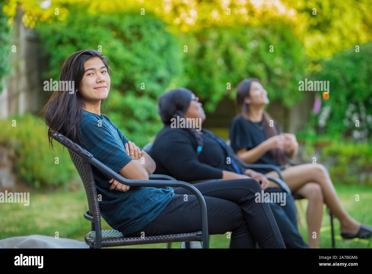 Freunde sitzen auf Liegestühlen im Freien sprechen im Sommer Stockfoto