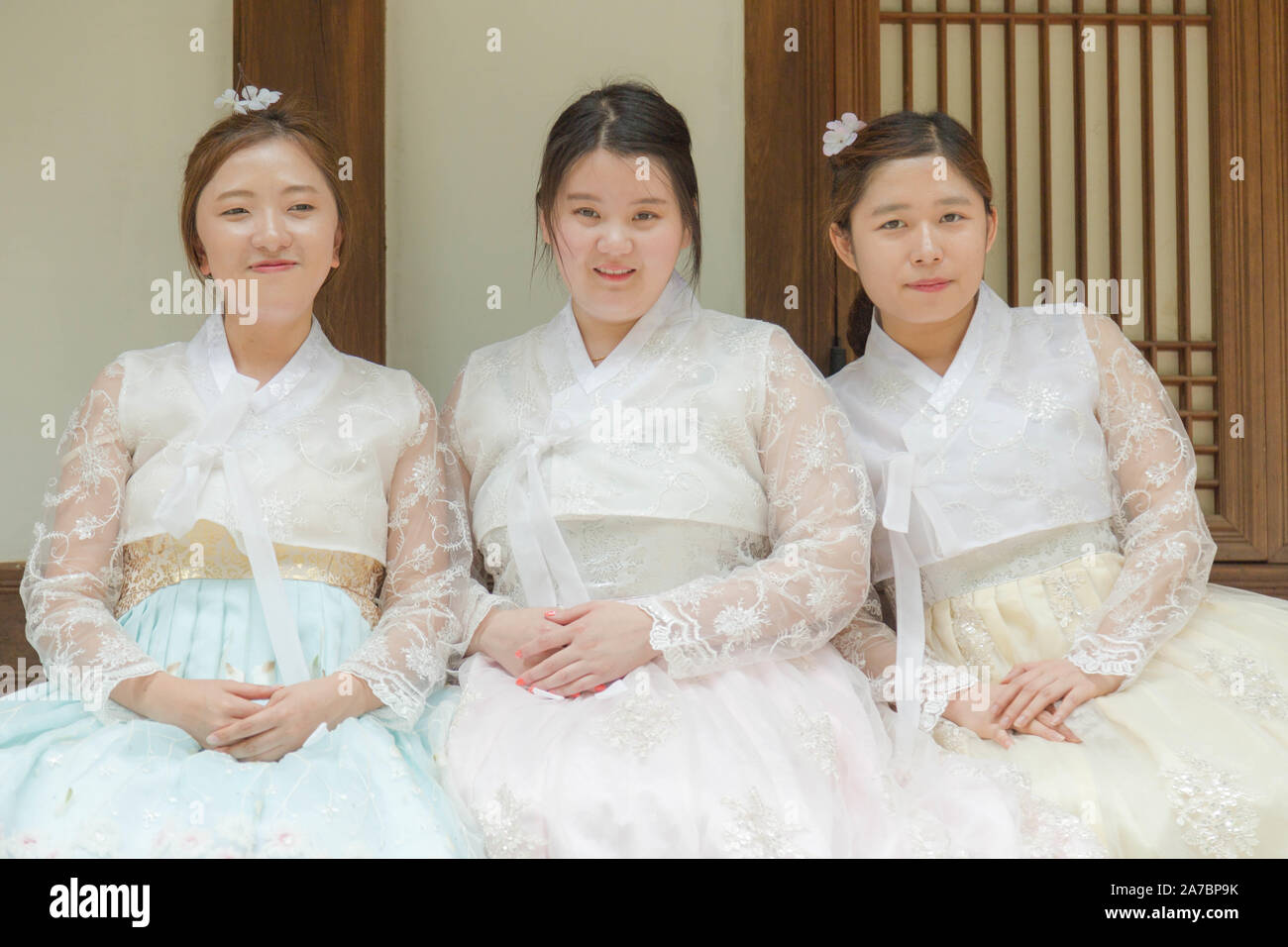 Das Dorf Bukchon Hanok, Seoul, Südkorea. Ein Porträt von drei jungen koreanischen Frauen im traditionellen Outfit. Stockfoto