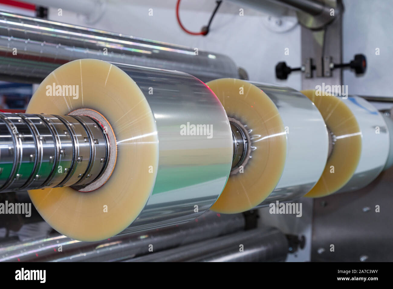 Rolle von Kunststoffverpackungen Film über die automatische Verpackungsmaschine in Essen Produkt factory. Industrie und Technologie Konzept. Stockfoto