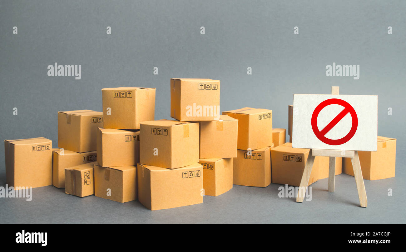 Viele Kartons und ein Zeichen stehen mit rotem Symbol Nr. Embargo, Handelskriege. Unfähigkeit, Produkte zu verkaufen, Verbot der Einfuhr. Beschränkung auf die impor Stockfoto