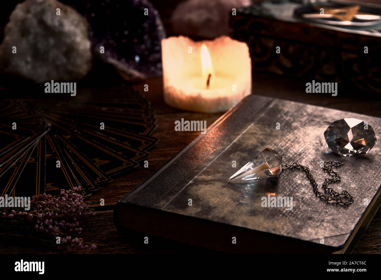 Stillleben mit Kerze auf alten hölzernen Tischplatte, schwarz Wahrsagerin Karte, Magic und Pentagramm Box und Kristall Pendel. Geeignet für mag Stockfoto