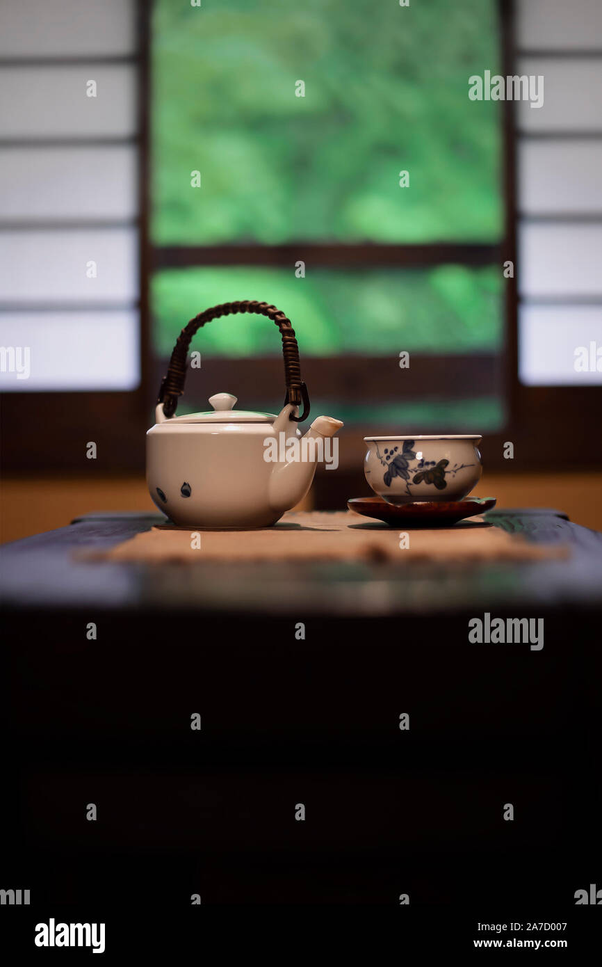 Teekanne und Tee Schale auf einem Tisch in einem traditionellen japanischen Zimmer vor Shoji Bildschirm windows Stockfoto