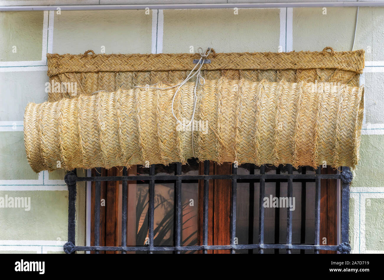 Esparto Shutter, aufgerollt, in der Außenseite der Fenster mit schwarzen Balken. Handgefertigtes Produkt das Haus der Sonneneinstrahlung und hohen Temperaturen zu schützen Stockfoto