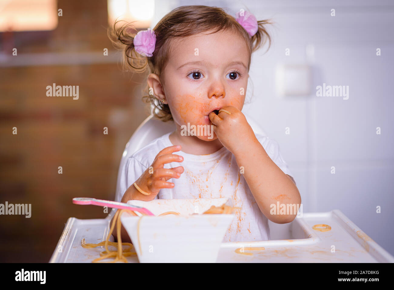 Susse Kleine 1 Jahrige Madchen Baby Kind In Einer Leistungsstarken Stuhl Zu Hause Sitzt Isst Nudeln Hande Foto Im Realen Leben Innenraum Self Futterung Conce Stockfotografie Alamy