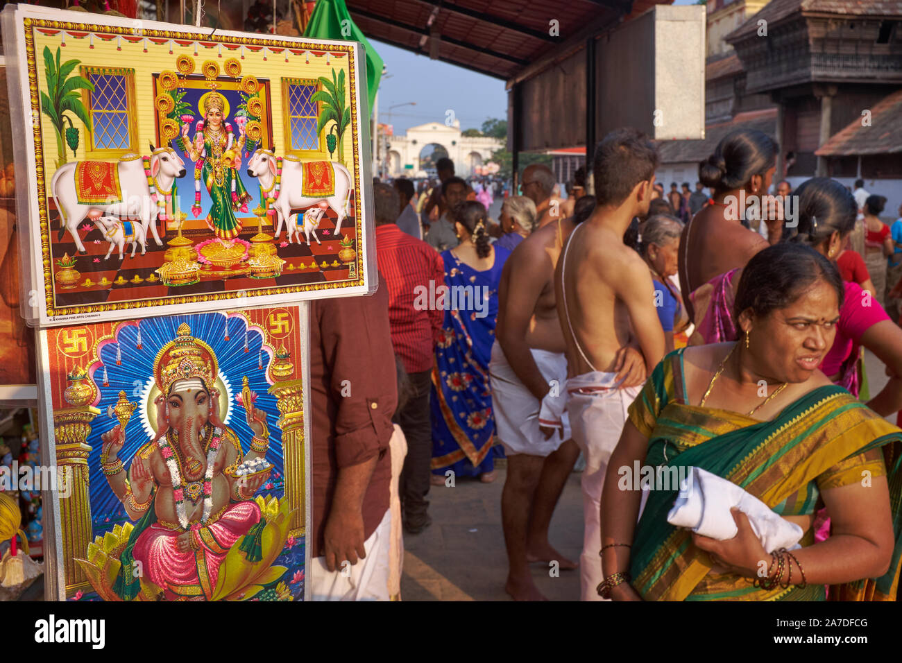 Eine Frau steht neben einem Verkauf außerhalb Padmanabhaswamy Temple in Trivandrum, Kerala, Indien, wo Bilder von hinduistischen Gottheiten sind ion Verkauf Abschaltdruck Stockfoto