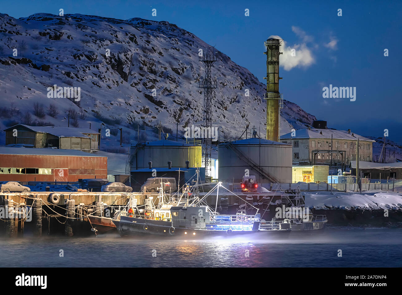 Die kleine Schiffe im Dock von Fisch verarbeitenden Betrieb bei Nacht. Teriberka, Region Murmansk, Kola Halbinsel. Russland Stockfoto