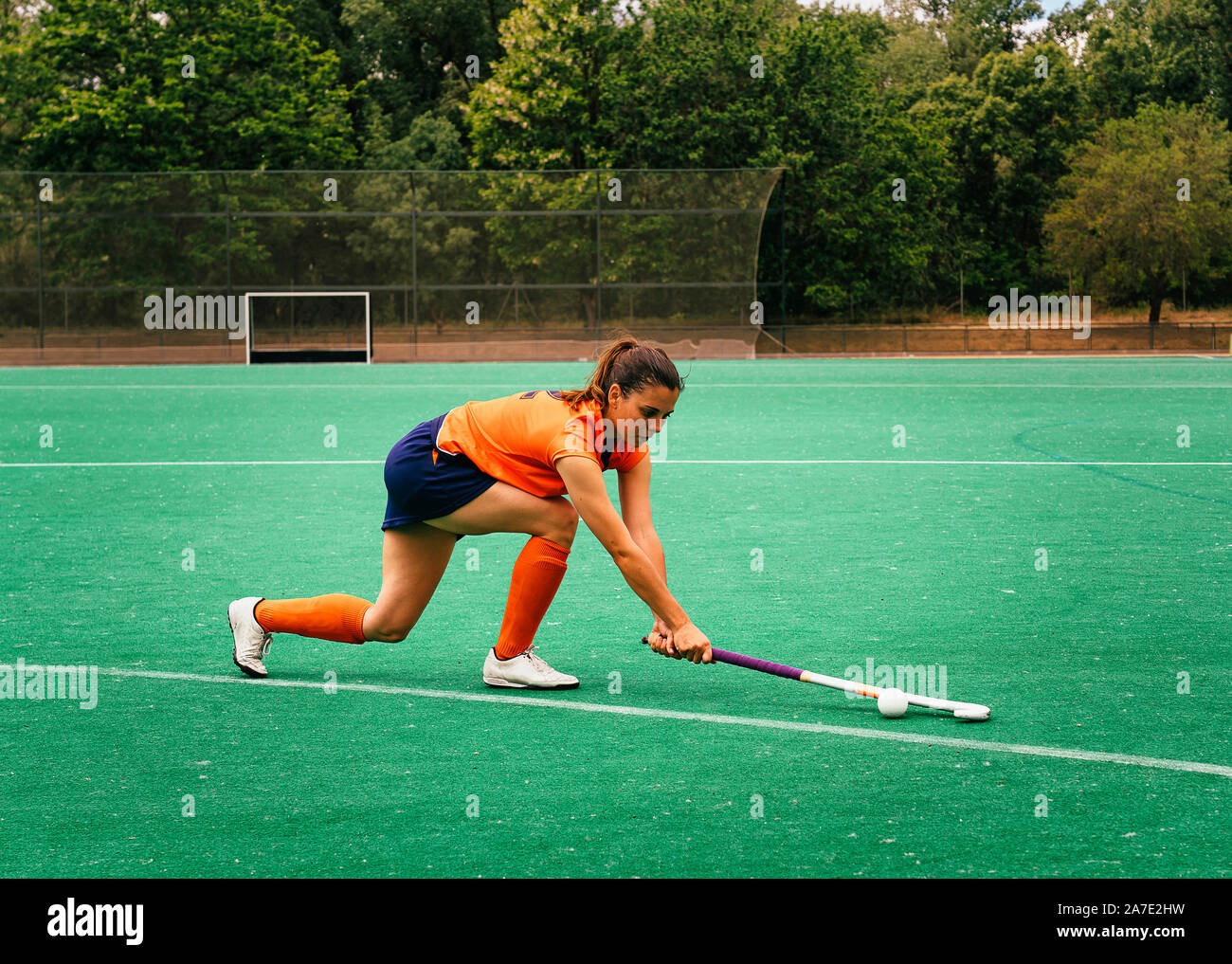 Weibliche hockey Spieler angreift und Schlagen auf eine Rasenfläche. Stockfoto