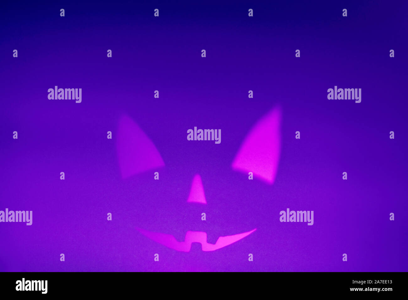 Schatten von Halloween scary pumpkin Gesicht auf Violett Papier Hintergrund. Halloween Horror Hintergrund. Kopieren Sie Platz. Magische Farben Stockfoto