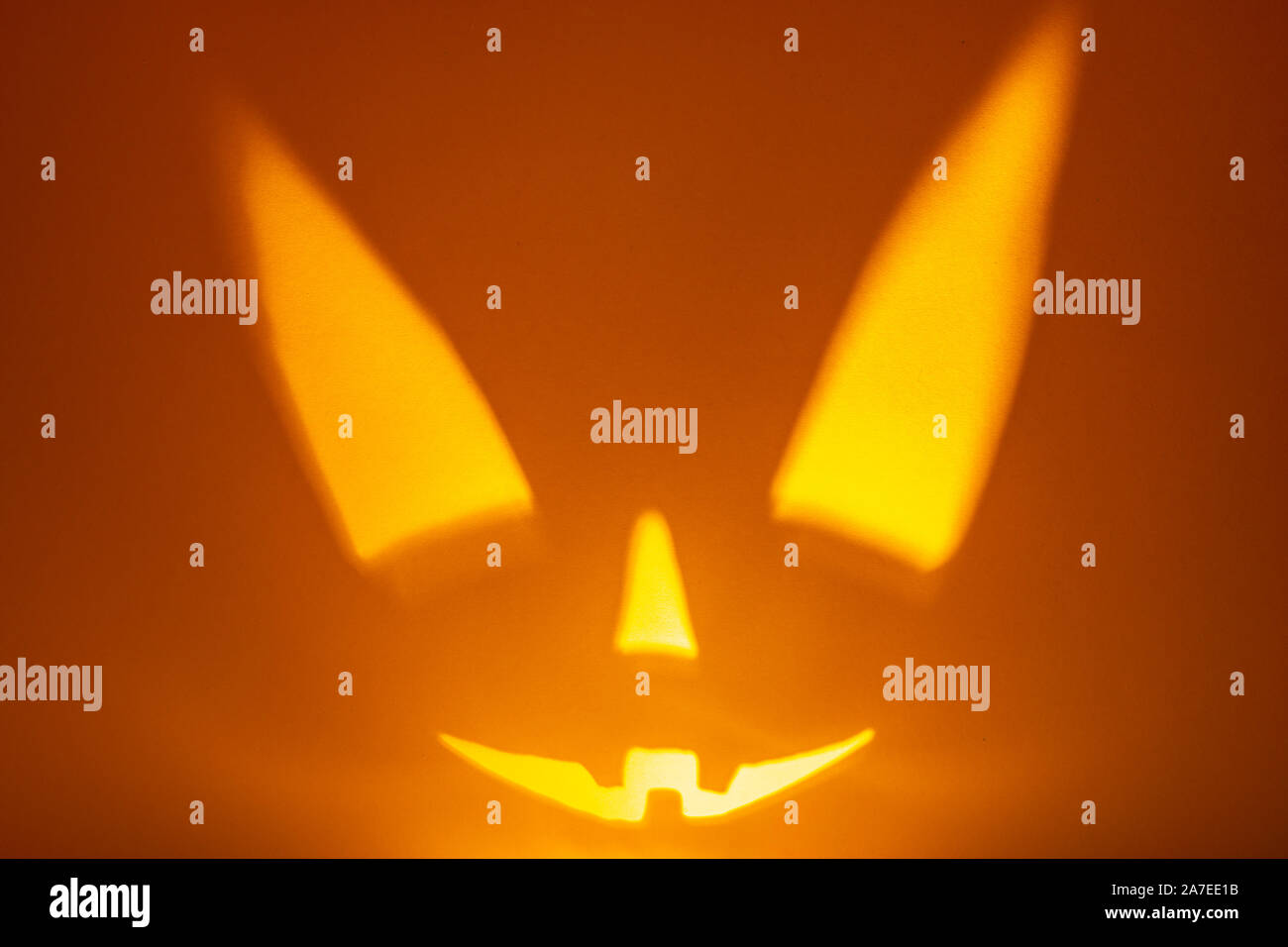Schatten von Halloween scary pumpkin Gesicht auf dunklen orange Papier Hintergrund. Schatten aus dem Feuer. Halloween Horror Hintergrund. Kopieren Sie Platz. Stockfoto