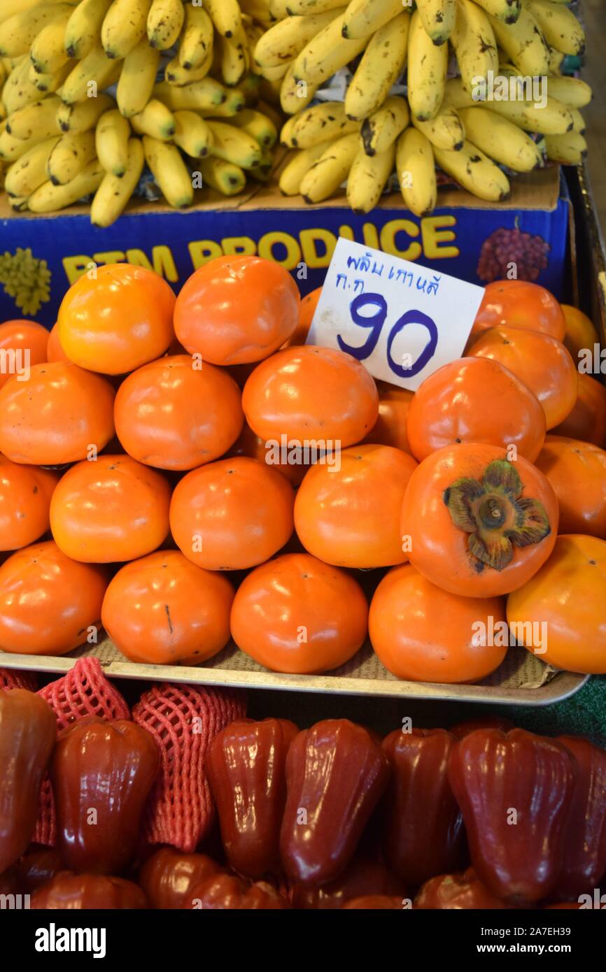 Frische Persimmons und Bananen auf dem traditionellen asiatischen Obstmarkt Stockfoto