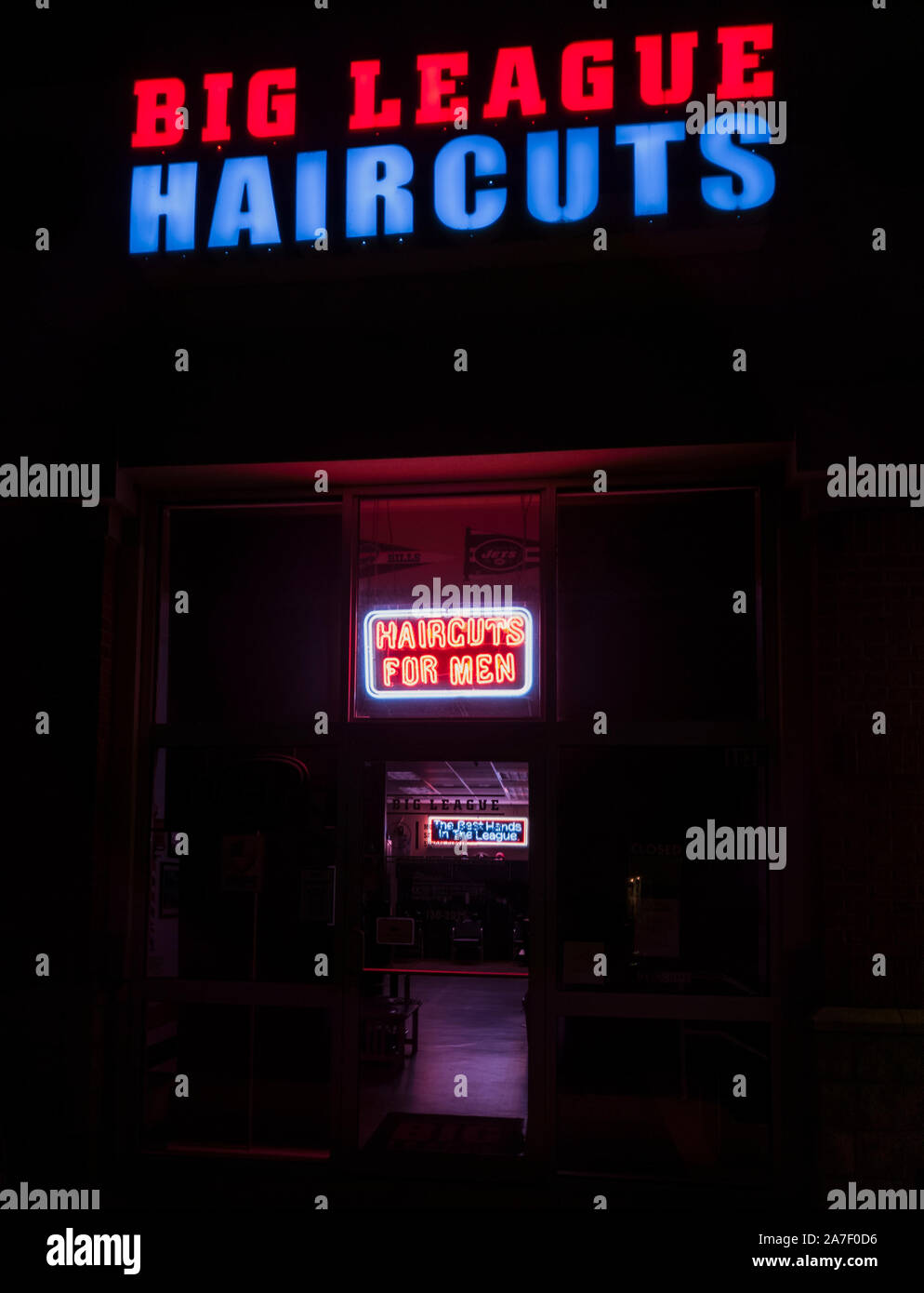 New Hartford, New York - May 14, 2019: Low Key Image für die Storefront Neonlichter der Big League Haarschnitte, Big League Haarschnitte ist ein Friseursalon op Stockfoto
