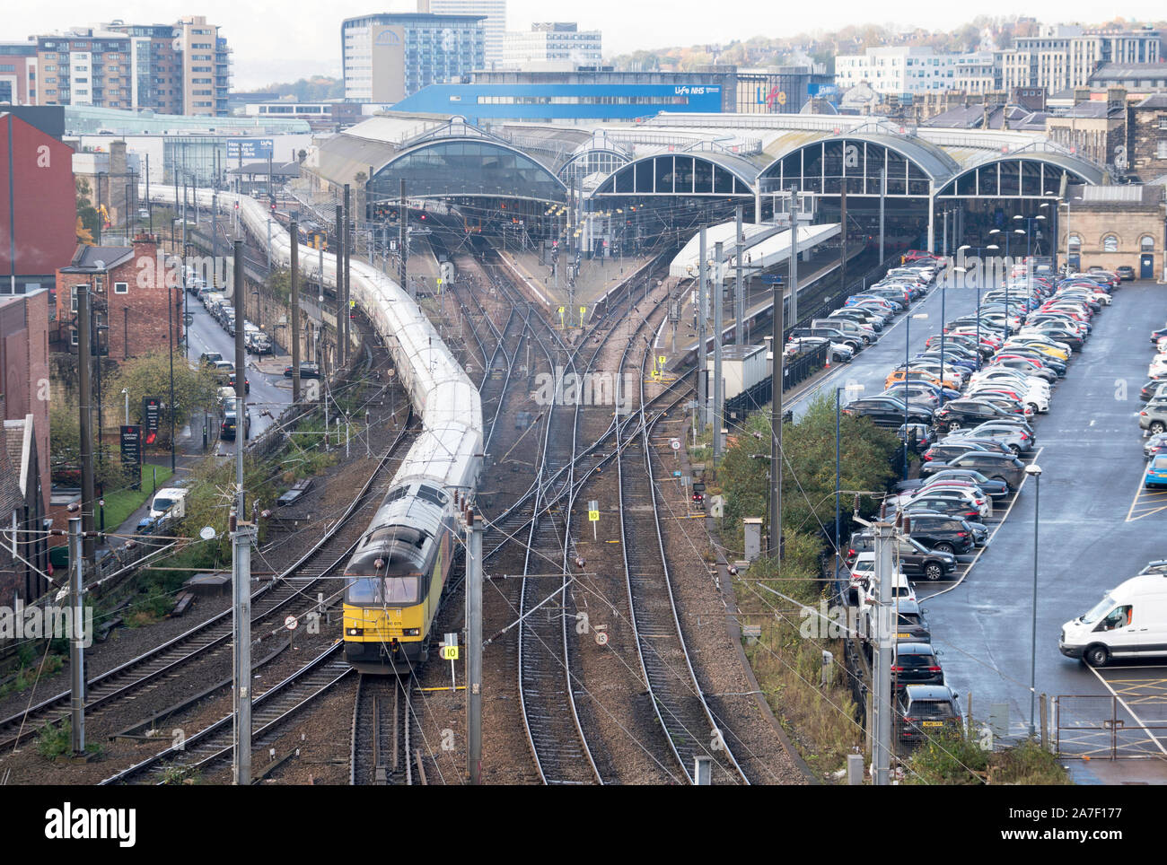 Eine lange Biomasse Güterzug von einer Klasse 60 Diesellok schlängelt, vorbei an der komplexen Kreuzung an den Hauptbahnhof von Newcastle, England, Großbritannien Stockfoto