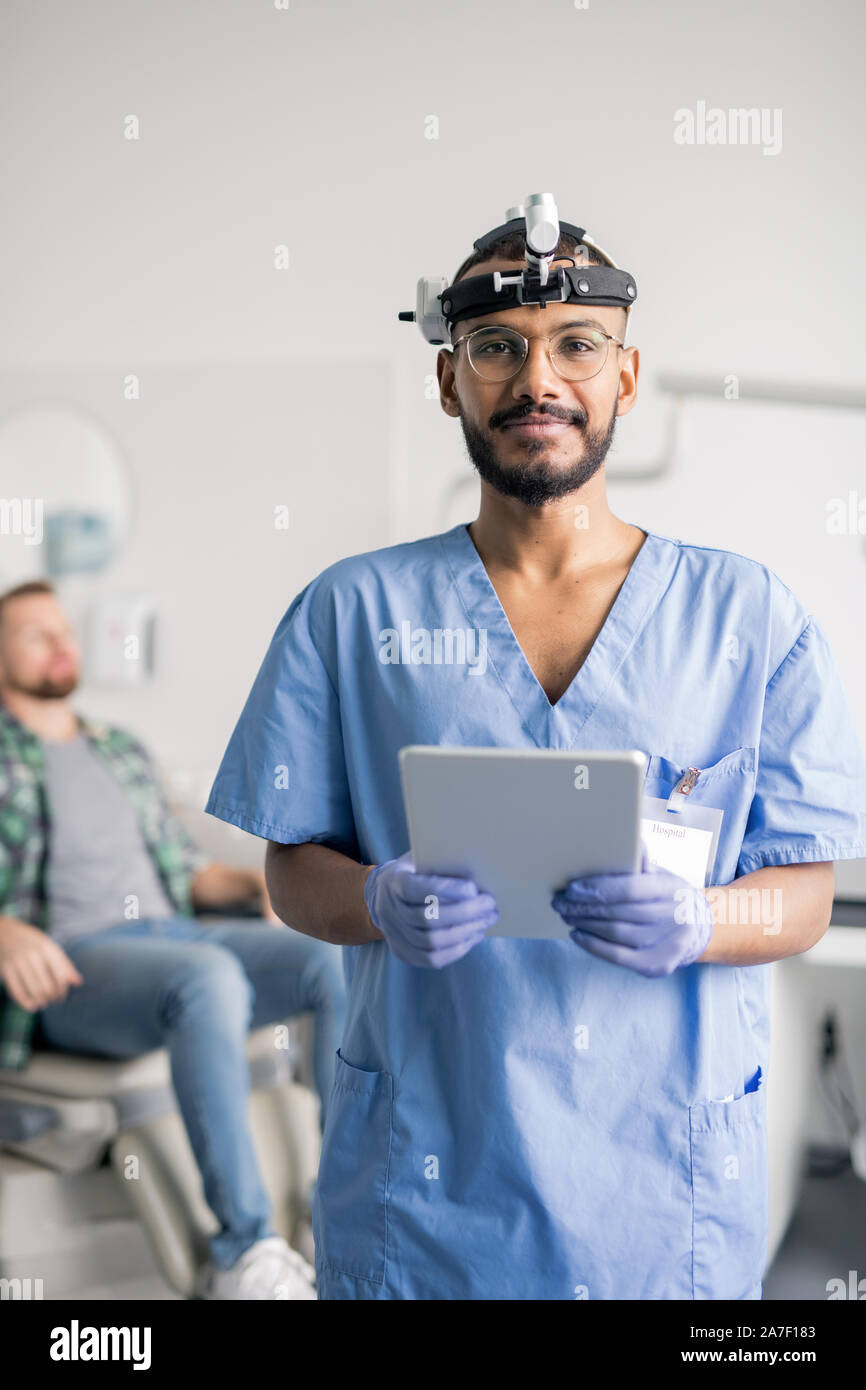 Erfolgreiche Arzt in Uniform und medizinische Ausrüstung Kopf mit Touchpad Stockfoto