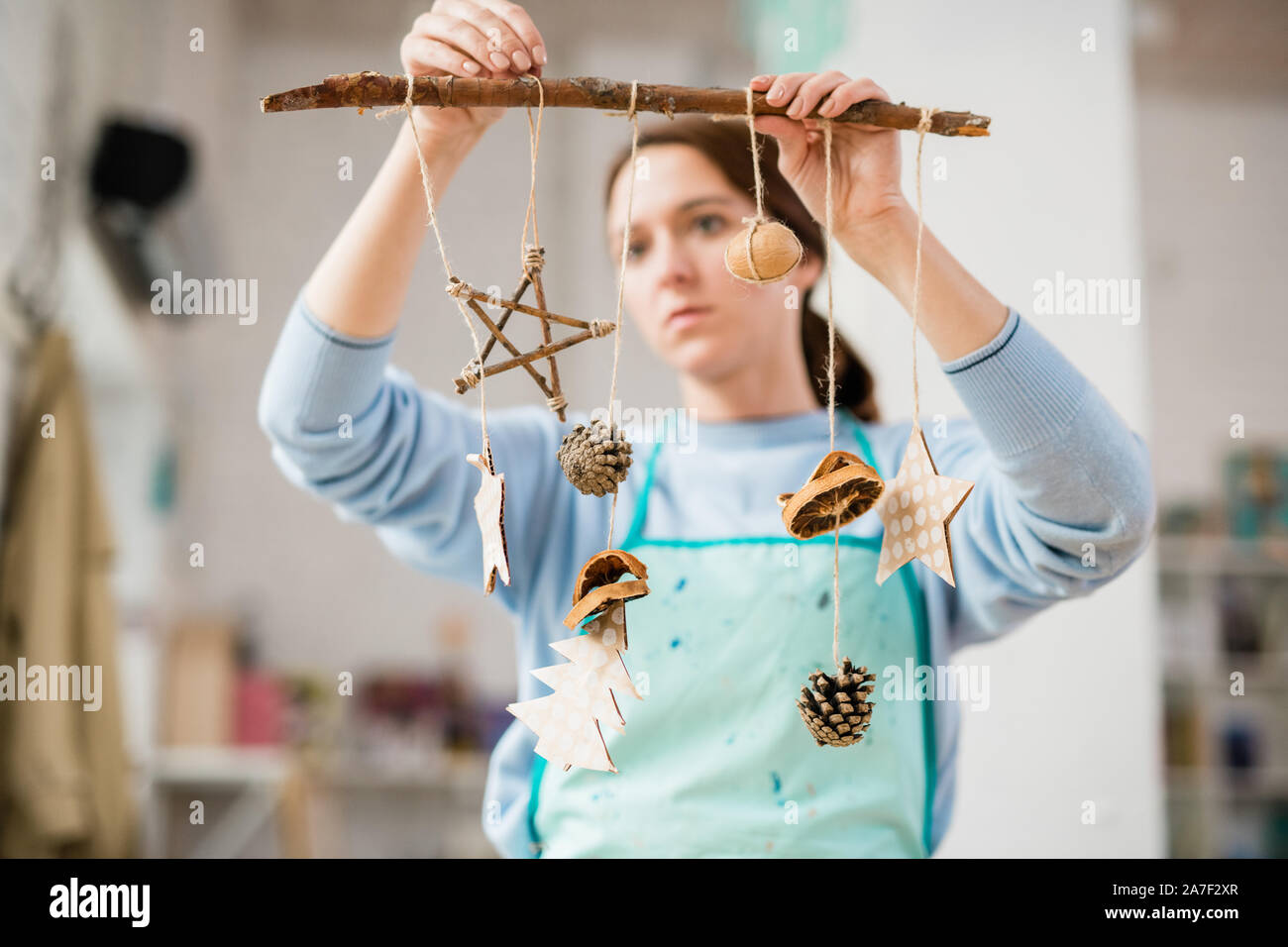 Junge Frau mit Stick mit handgefertigten Karton Weihnachtsschmuck Stockfoto