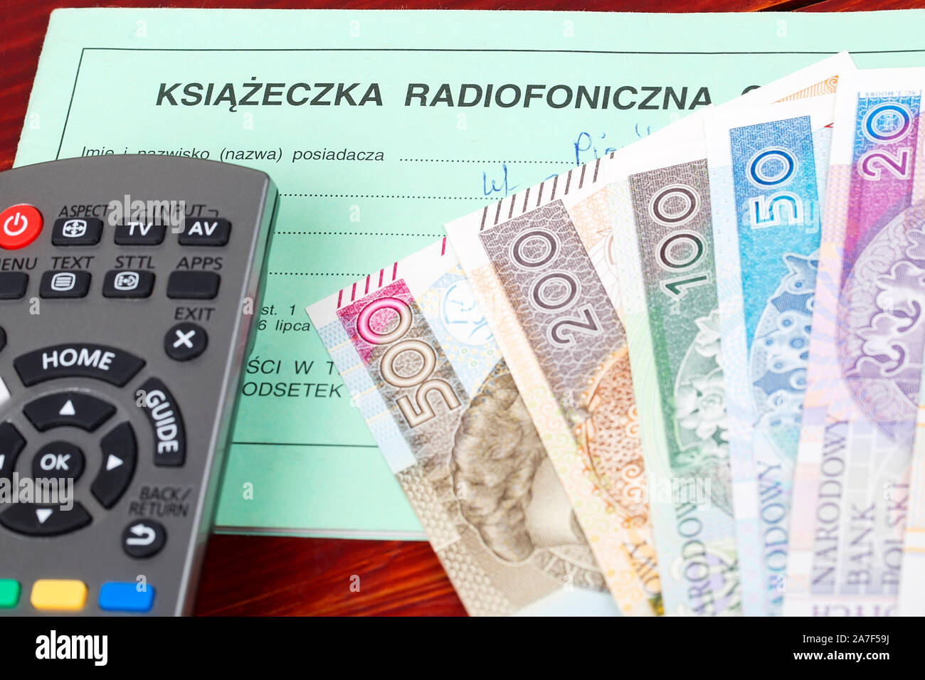 Polnische TV Abo Booklet mit einer Fernbedienung und Geld Stockfoto