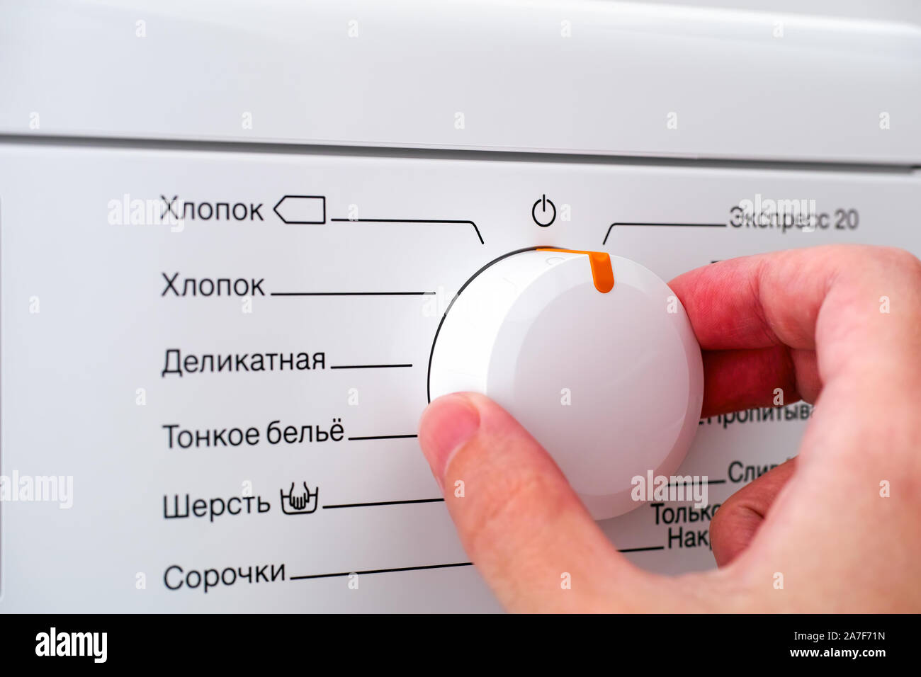 Nahaufnahme der Person hand Wahl Zyklus Programm auf der Waschmaschine. Stockfoto