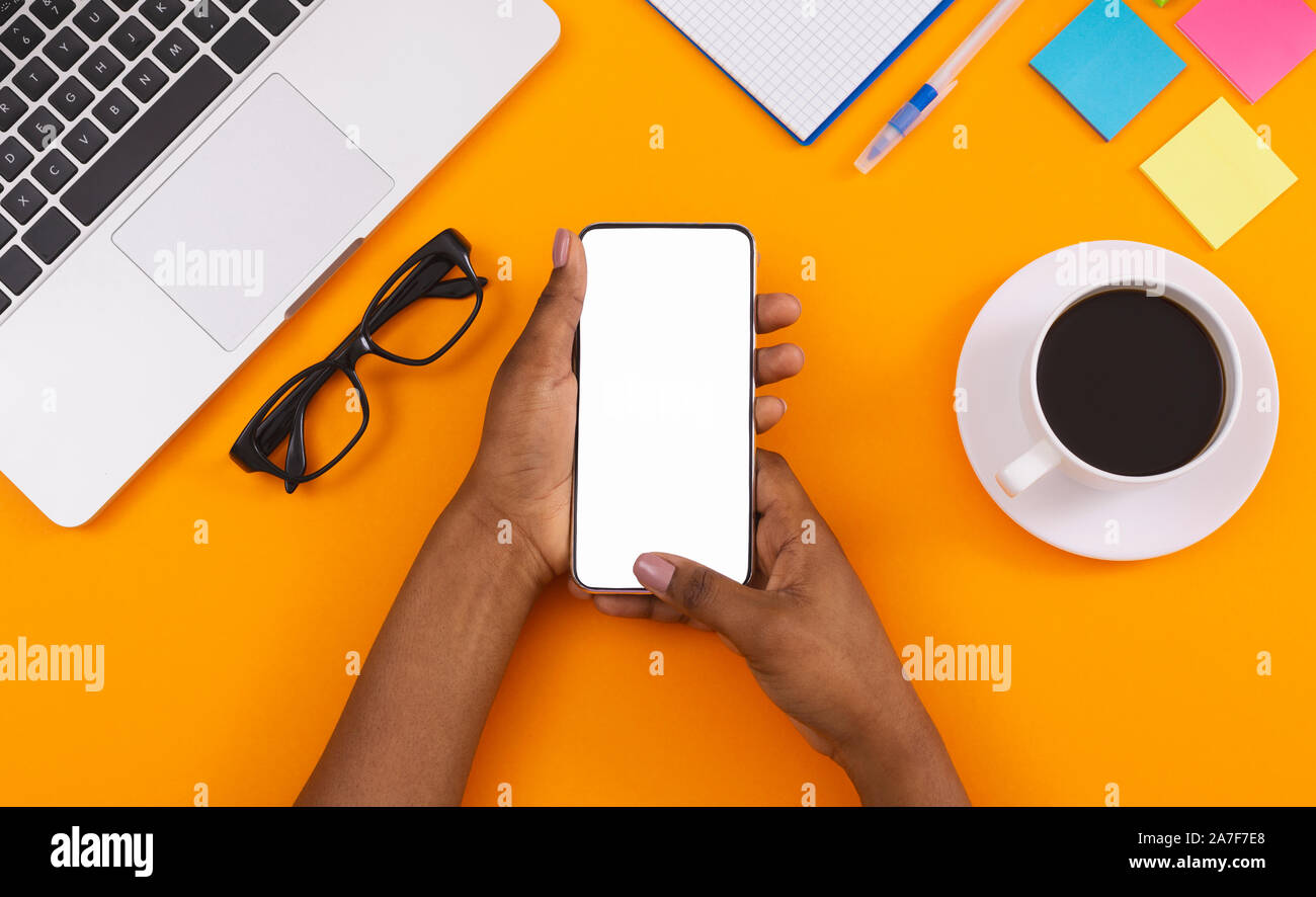 Schwarze Frau mit leerer Bildschirm am Arbeitsplatz smartphone Stockfoto