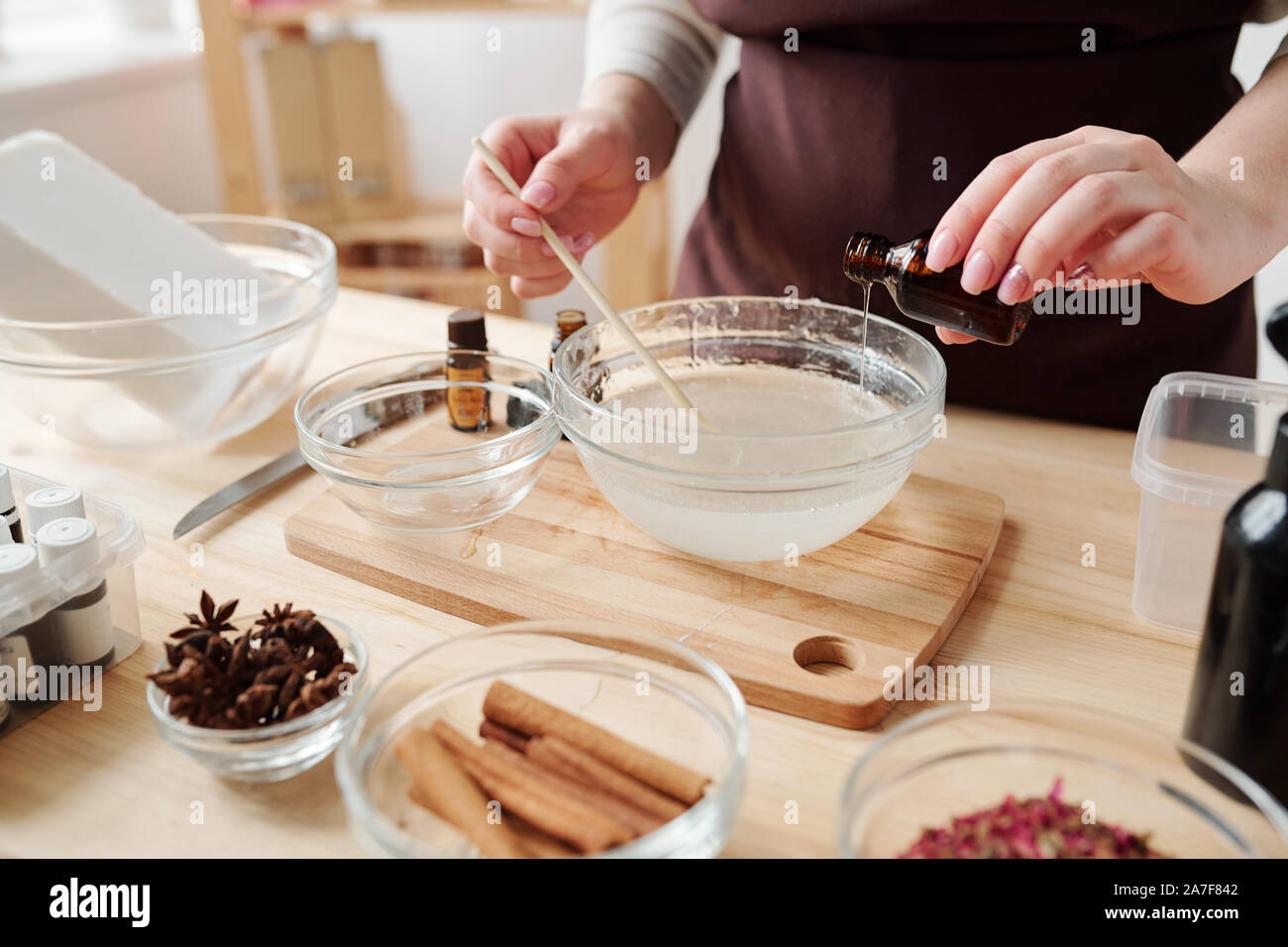 Junge weibliche Eine der wesentlichen Öle gießen in flüssige Seife Masse in Gläser Stockfoto