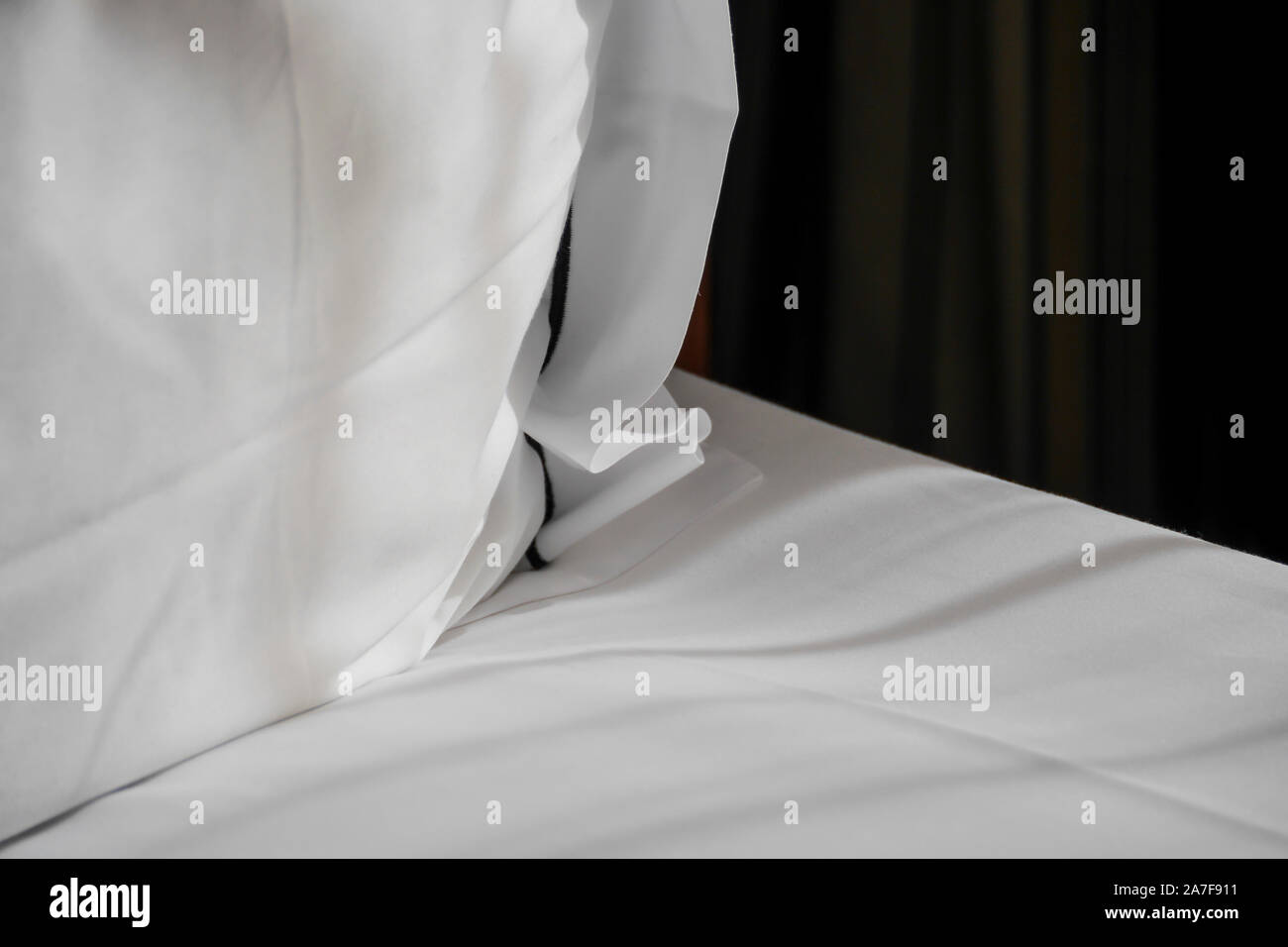 Saubere, weiße Bettwäsche und Kissen im Morgenlicht. Close Up. Stockfoto