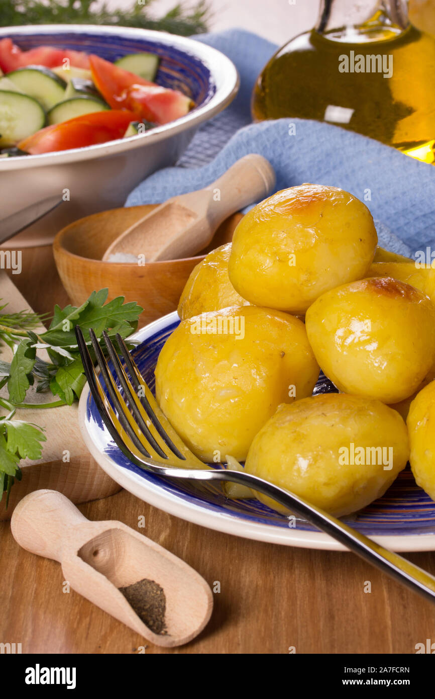 Frittierte Kartoffeln, Salat, Pflanzenöl auf dem Küchentisch Stockfoto