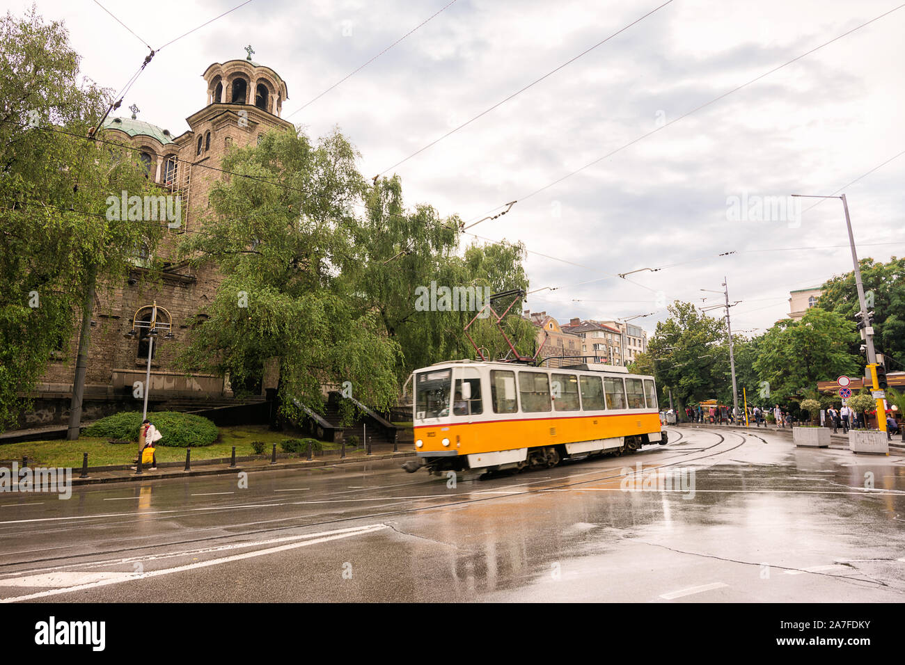 Sofia, Bulgarien - 24. Juni 2019: Straßenbahn, während der Regen in einer Straße in Sofia, mit der Kirche von Santa Domenica im Hintergrund Stockfoto