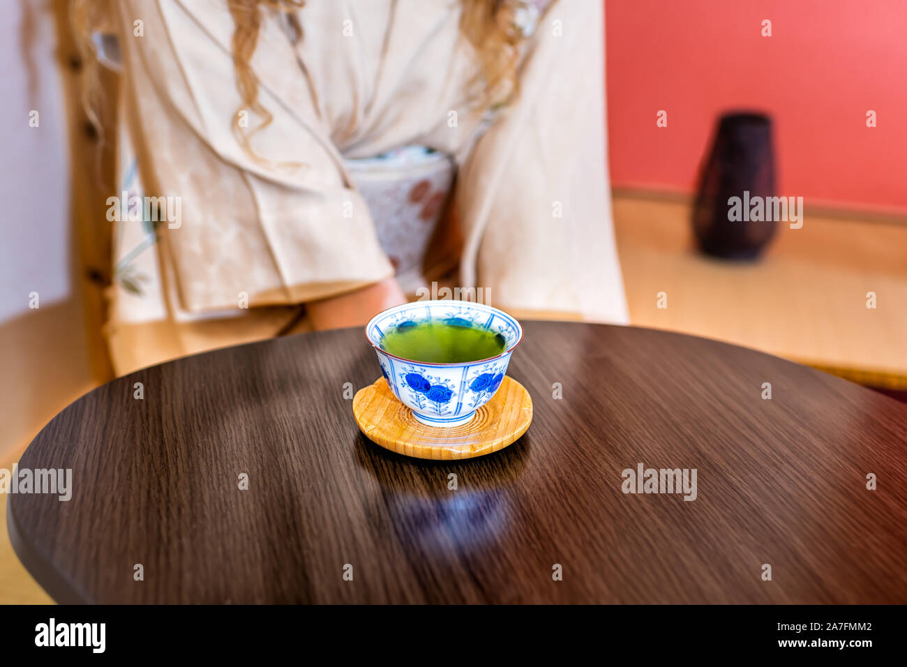 Traditionelle japanische Frau im Kimono Kostüm sitzt von Alkoven hängenden Blättern Papier trinken grünen Tee in der Zeremonie Stockfoto