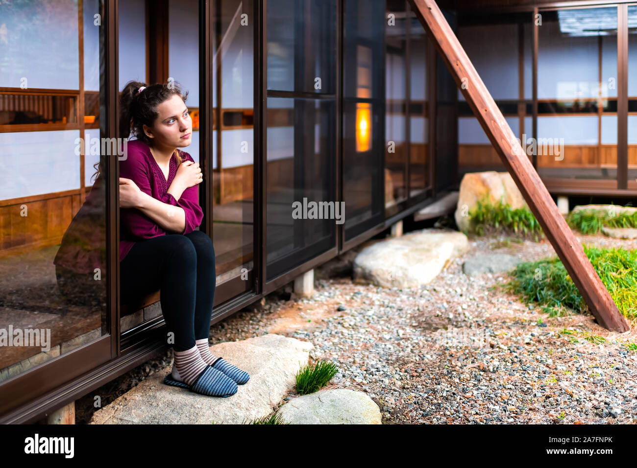 Junge Mädchen Frau sitzen Denken in Japan durch offene Fenster Schiebetür  indoor auf traditionellen Japanischen Garten mit Kies Stein im Haus  Stockfotografie - Alamy