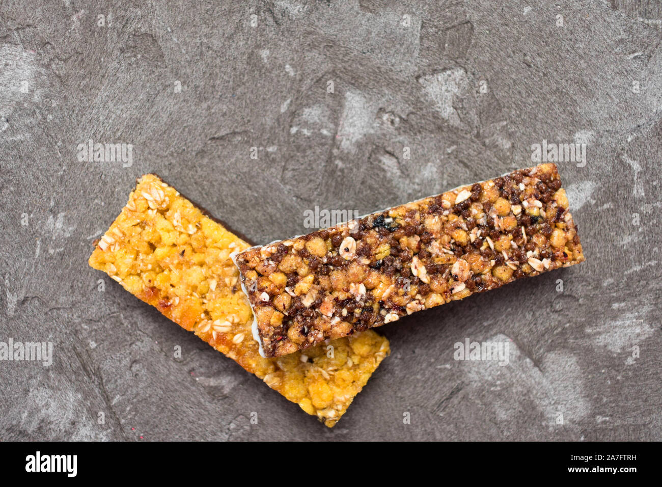Zwei Müsliriegel auf grauem Hintergrund. Die Aussicht von oben. Kopieren Sie Platz. Stockfoto