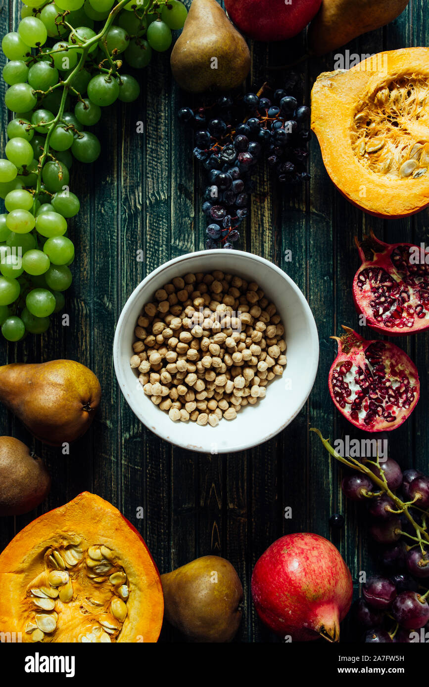Die herbstlichen Obst, gesundes Müsli Hintergrund, typischen Früchte der herbstlichen Jahreszeit, biologisch angebaute, runden Schalen voller gesunder Getreide Hafer Stockfoto