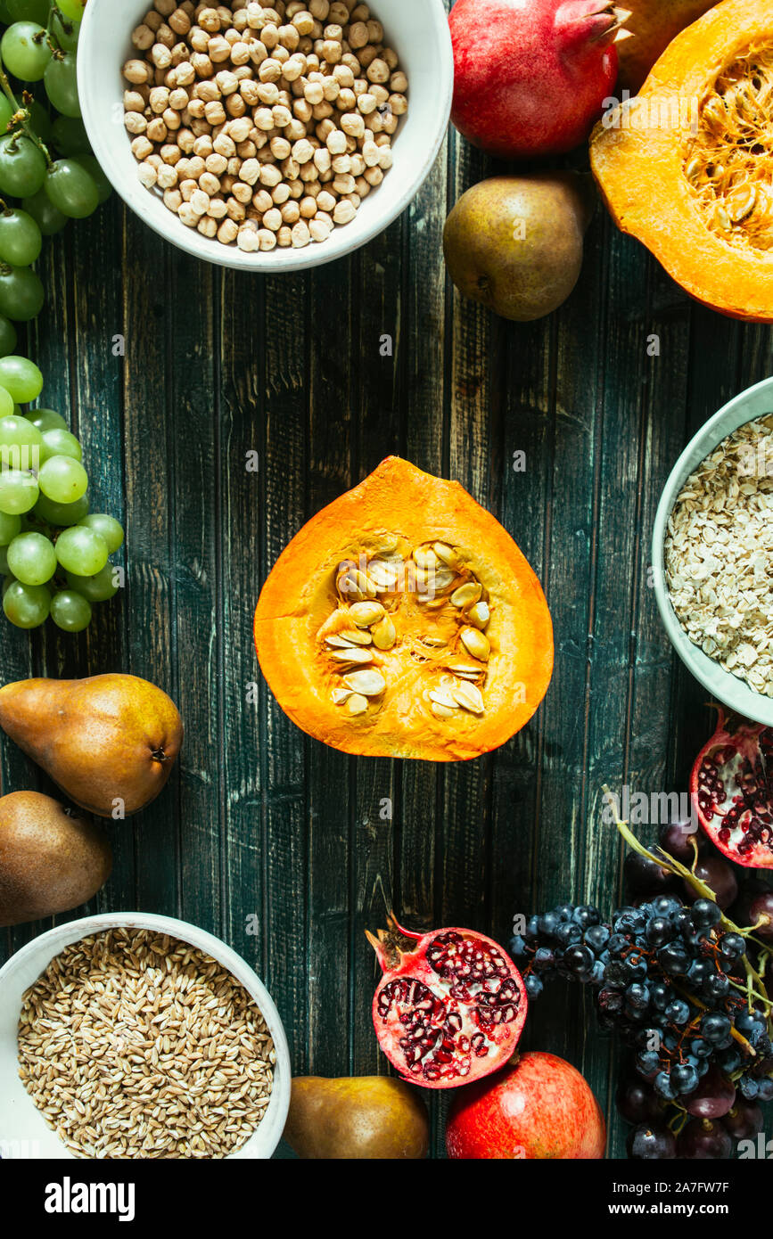 Die herbstlichen Obst, gesundes Müsli Hintergrund, typischen Früchte der herbstlichen Jahreszeit, biologisch angebaute, runden Schalen voller gesunder Getreide Hafer Stockfoto