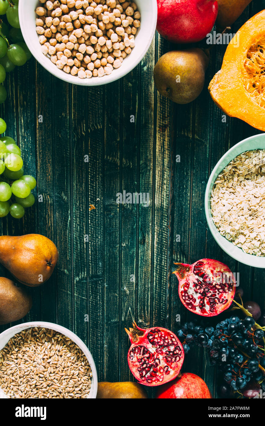 Die herbstlichen Obst, gesundes Müsli Hintergrund, typischen Früchte der herbstlichen Jahreszeit, biologisch angebaute, runden Schalen voller gesunder Getreide Hafer Stockfoto