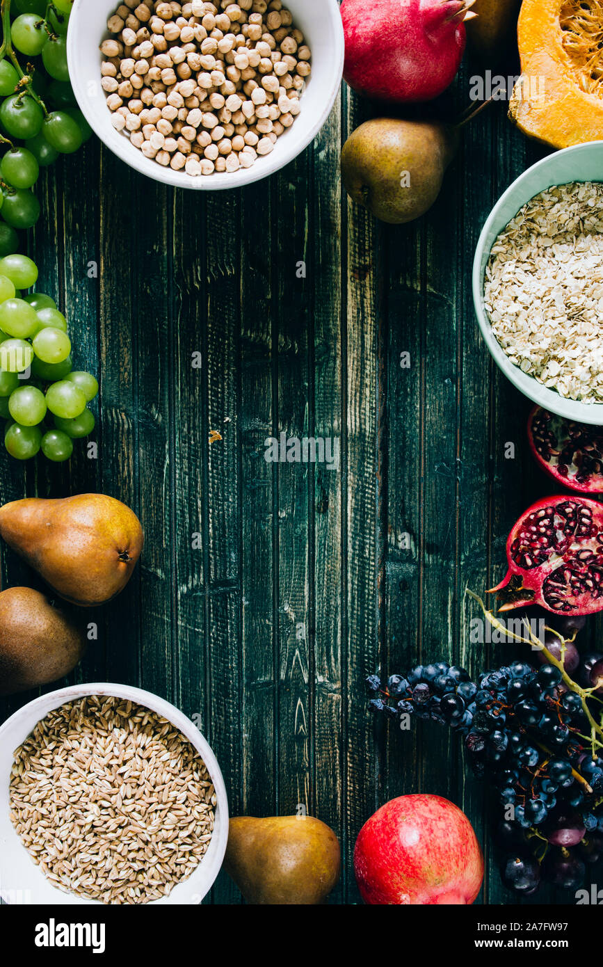 Die herbstlichen Obst, gesundes Müsli Hintergrund, typischen Früchte der herbstlichen Jahreszeit, biologisch angebaute, runden Schalen voller gesunder Getreide Hafer Stockfoto