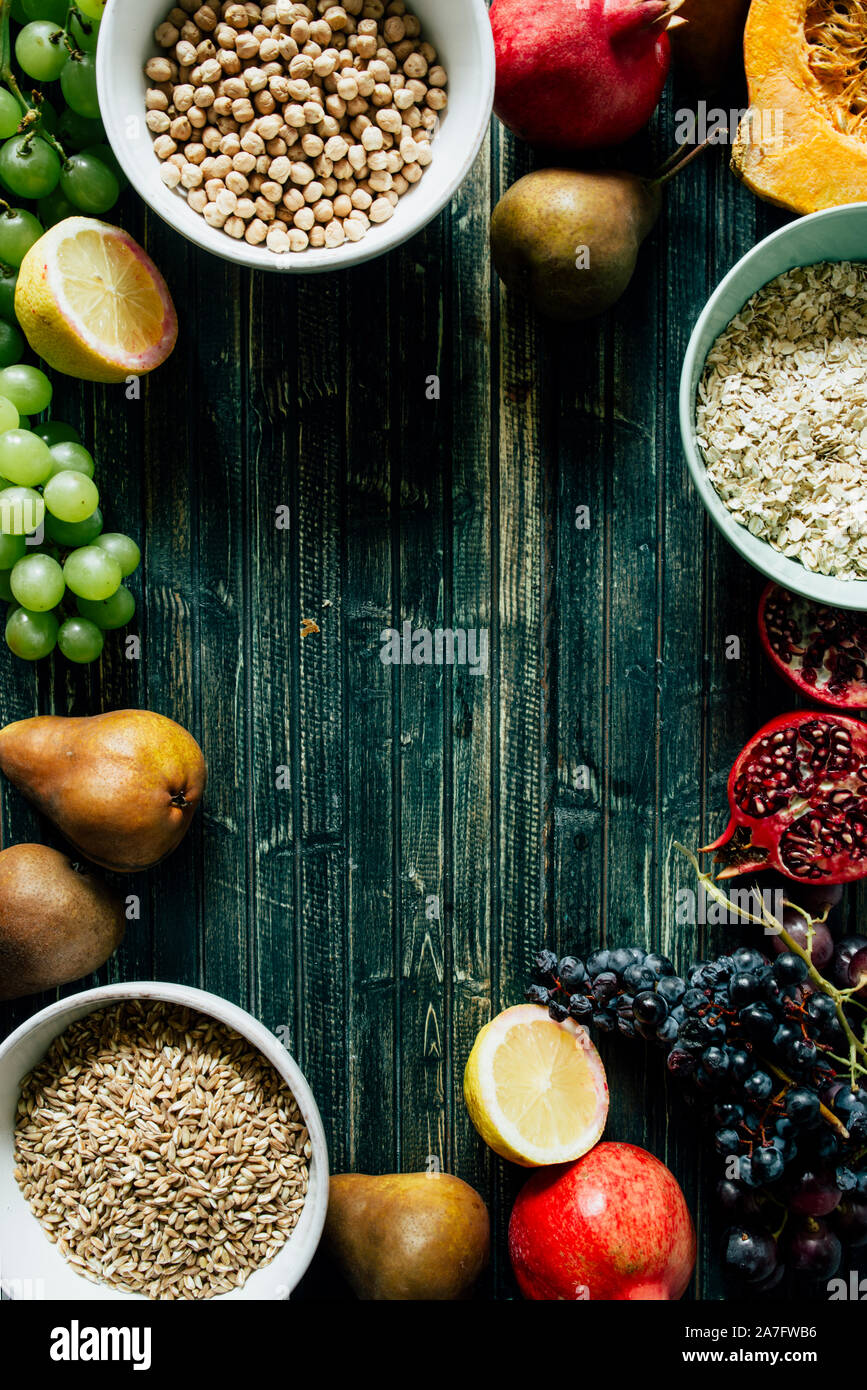Die herbstlichen Obst, gesundes Müsli Hintergrund, typischen Früchte der herbstlichen Jahreszeit, biologisch angebaute, runden Schalen voller gesunder Getreide Hafer Stockfoto