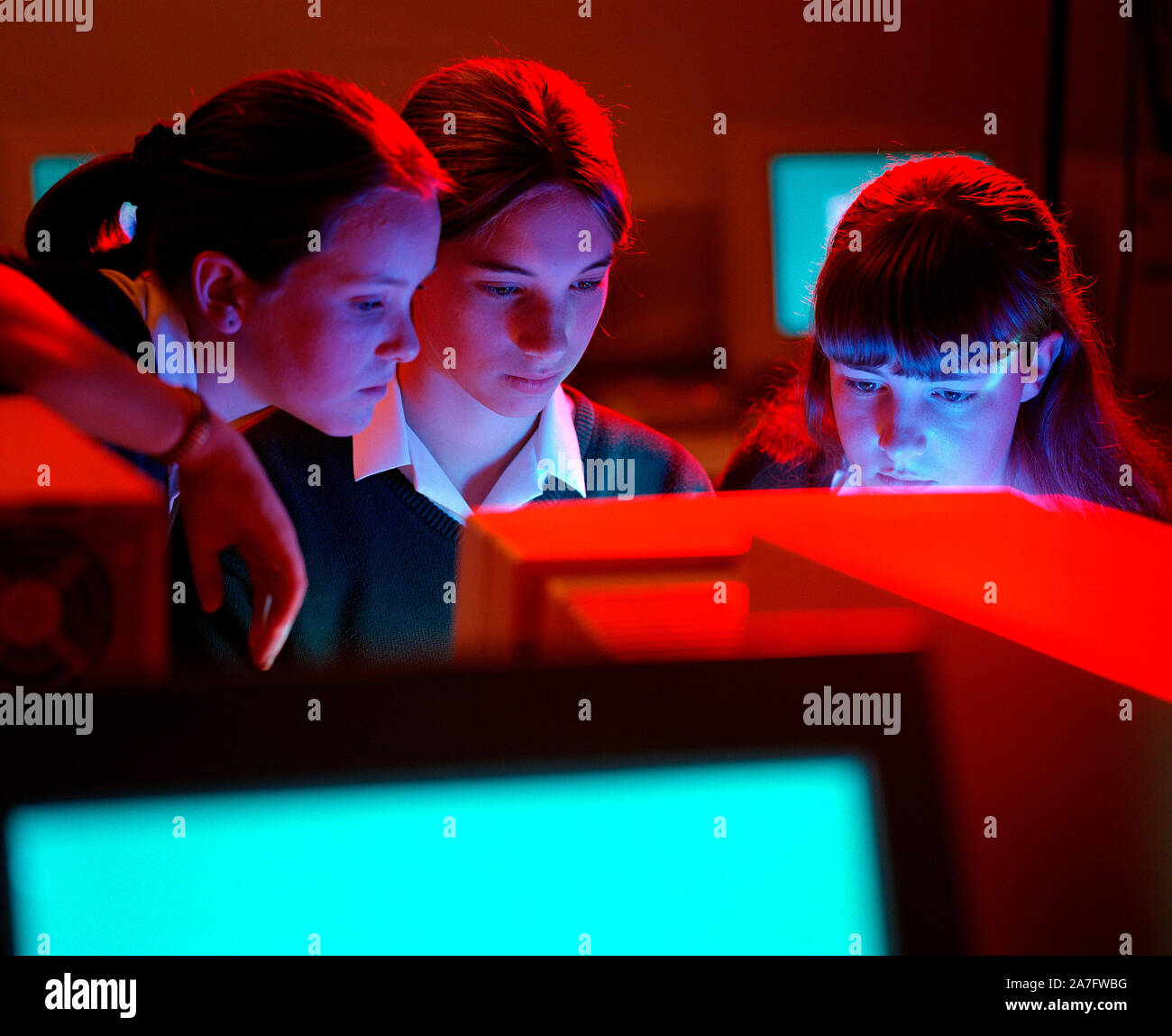 Kinder. Drei Schülerinnen mit Computer im Klassenzimmer. Stockfoto