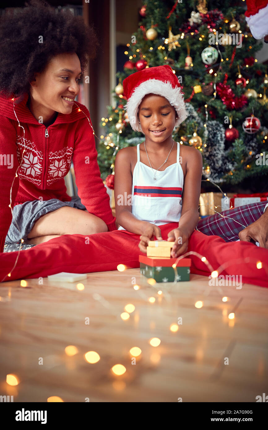 Süße Mädchen öffnet ein Geschenk für Weihnachten Morgen und Spaß haben Stockfoto