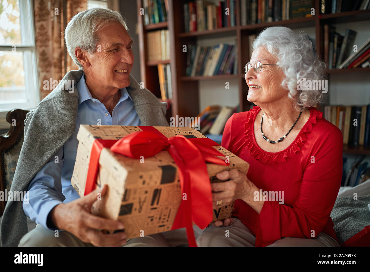 Lächelnd älterer Mann und Frau ihre Weihnachtsgeschenke austauschen Stockfoto