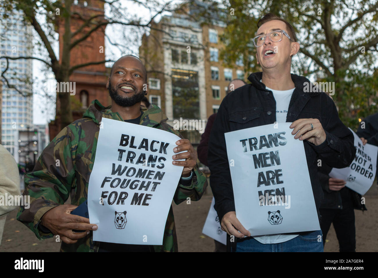 London, Großbritannien. November 2019. Zwei Demonstranten halten Plakate bei einer Queer Solidarity-Demonstration auf dem Soho-Platz: "TRANS-MÄNNER SIND MÄNNER" und "SCHWARZE TRANS-FRAUEN HABEN FÜR MICH GEKÄMPFT", die sich für Transgender- und nicht-binäre Rechte einsetzen. Die von Queer Solidarity organisierte Veranstaltung versammelte Aktivisten und Verbündete in einer öffentlichen Show der Unterstützung und Sichtbarkeit. Penelope Barritt/Alamy Live News Stockfoto