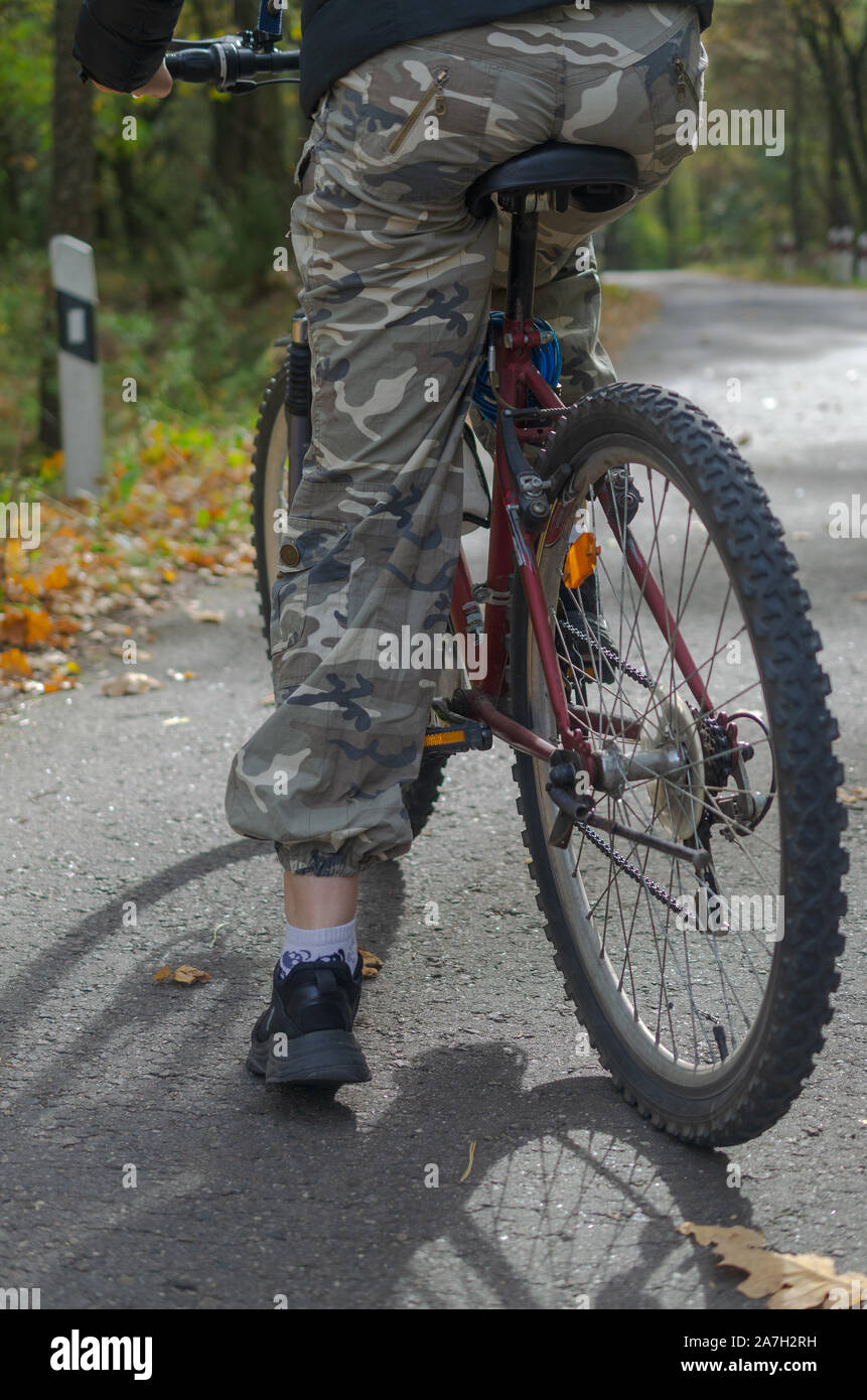 Ein Mädchen in Camouflage Hosen auf einem Fahrrad steht auf der Straße  Stockfotografie - Alamy