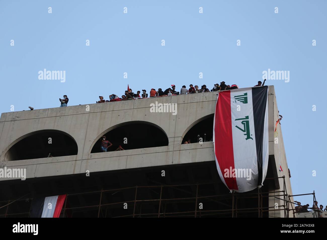 Bagdad, Irak. 2 Nov, 2019. Die Demonstranten sind auf einem Gebäude in Bagdad, Irak, an November 2, 2019 gesehen. Die irakischen Behörden am Samstag reduziert die Ausgangssperre in Bagdad nach vier Stunden von sechs, wie Demonstrationen gegen die Regierung in der irakischen Hauptstadt fort. Quelle: Khalil Dawood/Xinhua/Alamy leben Nachrichten Stockfoto