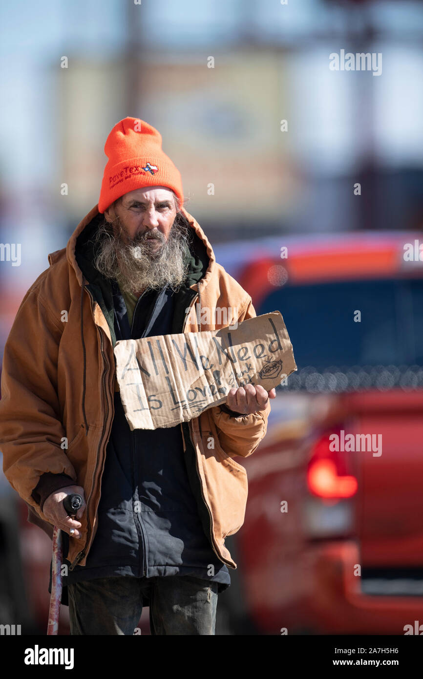 Obdachloser pfannenstiele für Geld an einer belebten Kreuzung in der Nähe von einem obdachlosen Lager unter einer Autobahnbrücke Tage vor einer drohenden Niederschlagung von Texas Gouverneur Greg Abbott auf öffentlichen Vorfahrt Camping. Stockfoto