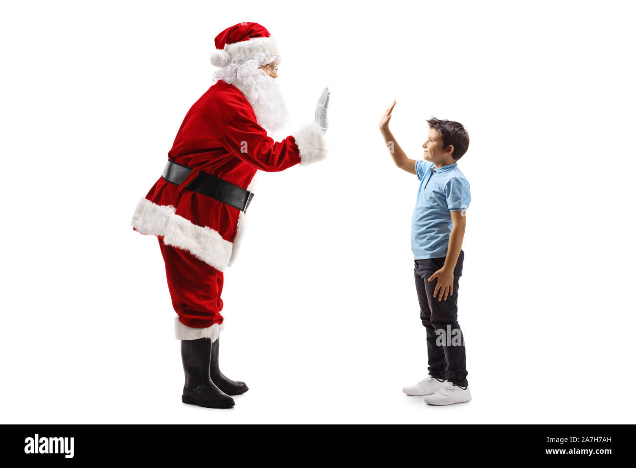 Volle Länge Profil Schuß von Santa Claus Gestik Höhe - fünf mit einem kleinen Jungen auf weißem Hintergrund Stockfoto