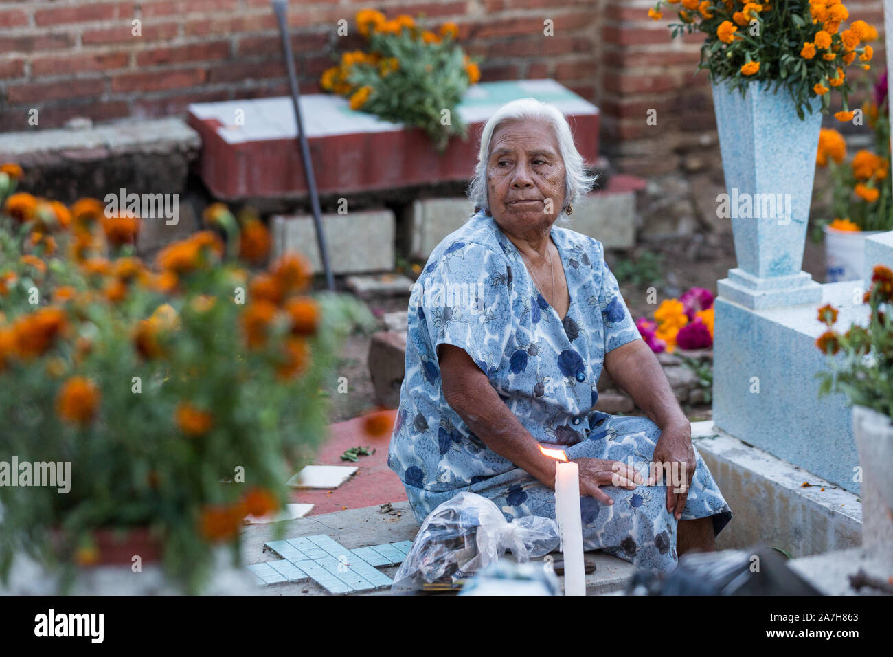 Eine alte mexikanische Frau am Grab von Angehörigen für Tag der Toten Festival in Spanisch bekannt als Día de Muertos am alten Friedhof 31. Oktober in Xoxocotlan, Mexiko 2013. Das Festival feiert das Leben derer, die gestorben sind. Stockfoto