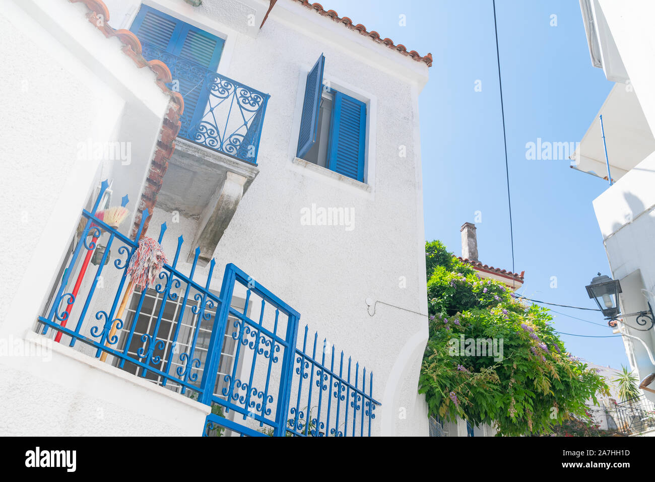 Typische griechische Insel weiß und blau Architektur mit Besen und Wischmop auf kobalt blau schmiedeeiserne Geländer. Stockfoto