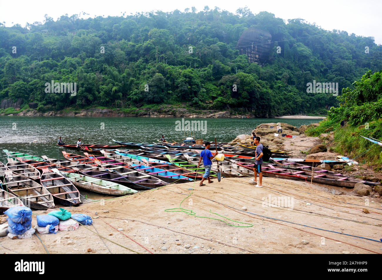 Dawki, Shillong, Meghalaya, 16. Juni, 2019: Touristen, bunte Boote aus Holz, Umngot Fluss in dawki von Shillong, Meghalaya mit dem Himmel und Hügel Stockfoto