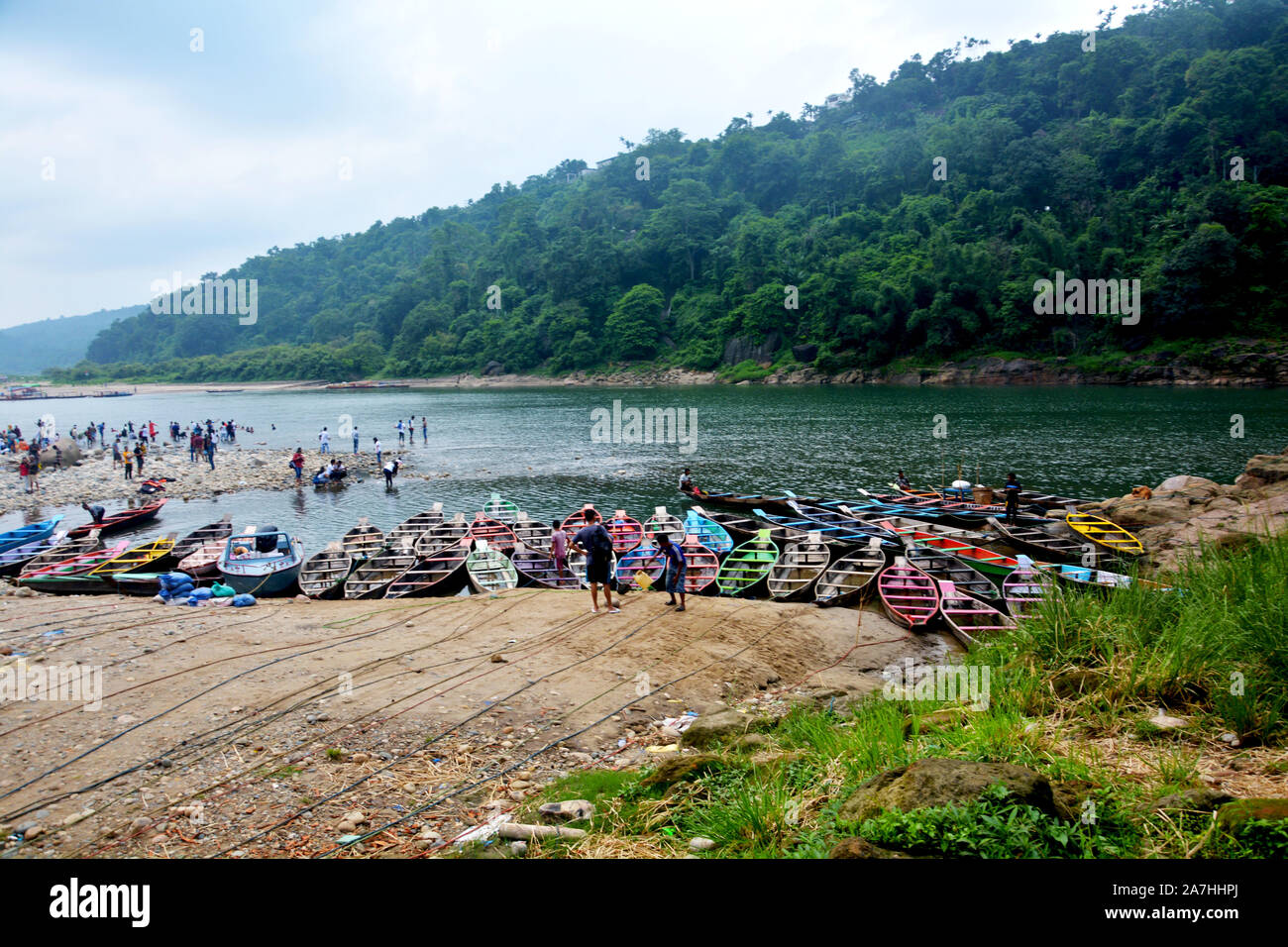 Dawki, Shillong, Meghalaya, 16. Juni, 2019: Touristen, bunte Boote aus Holz, Umngot Fluss in dawki von Shillong, Meghalaya mit dem Himmel und Hügel Stockfoto